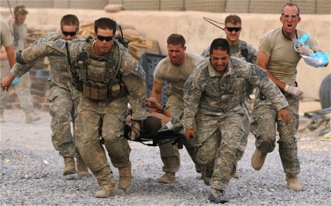photo of soldiers rushing injured GI out of battle